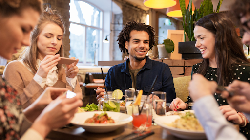 Group of friends enjoying a meal together at a restaurant table.